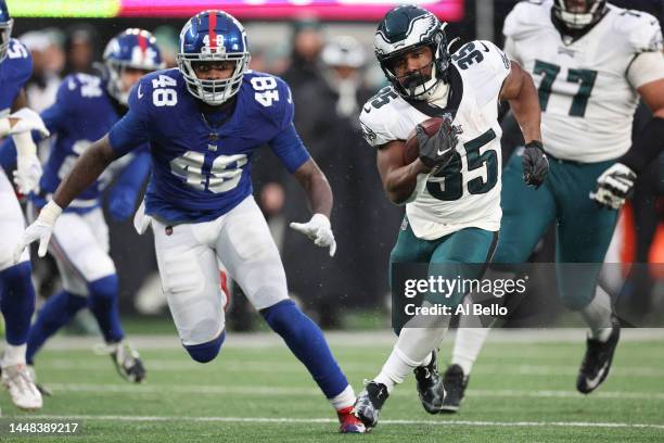 Boston Scott of the Philadelphia Eagles runs the ball in front of Tae Crowder of the New York Giants during the second half at MetLife Stadium on...