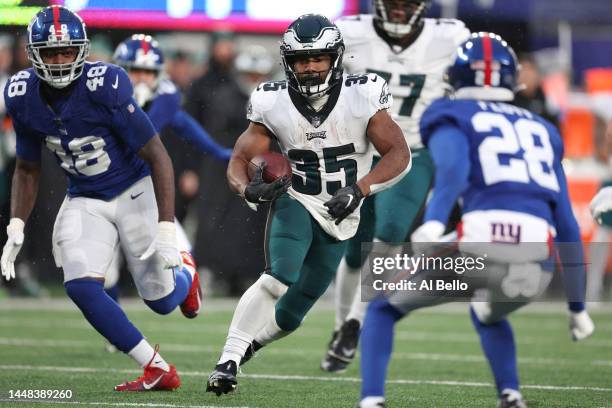 Boston Scott of the Philadelphia Eagles runs the ball against Tae Crowder and Cor'Dale Flott of the New York Giants during the second half at MetLife...