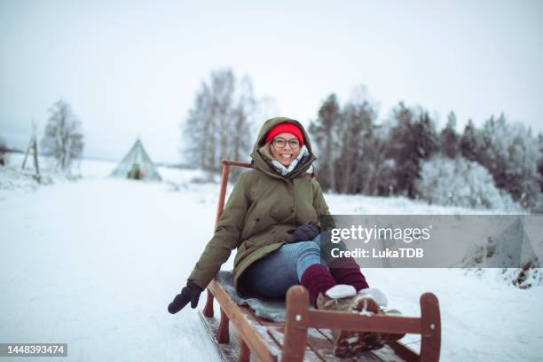 happy woman having crazy fun sledding - finnish lapland stock pictures, royalty-free photos & images