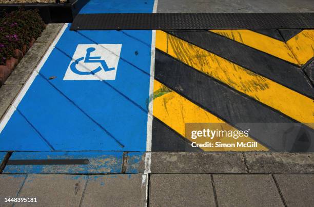 concrete wheelchair access ramp next to a building's driveway to its underground parking garage - handicap photos et images de collection