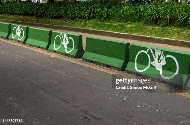 concrete barrier separating a cycling lane from other vehicle traffic lanes in bogota, colombia - construction barrier stock-fotos und bilder