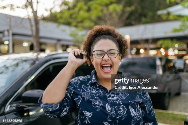woman celebrating the purchase of a new car - tweedehands autoverkoop stockfoto's en -beelden