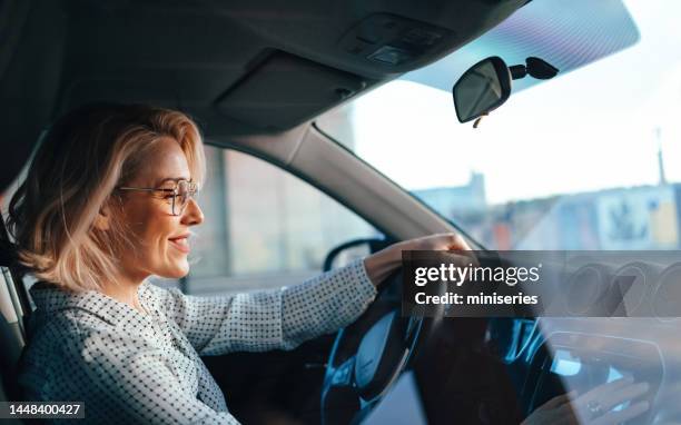 smiling businesswoman driving car - business person driving stockfoto's en -beelden