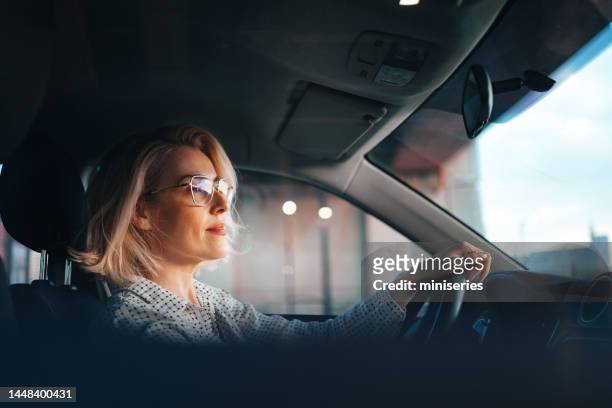 feliz empresaria conduciendo coche - woman driving fotografías e imágenes de stock