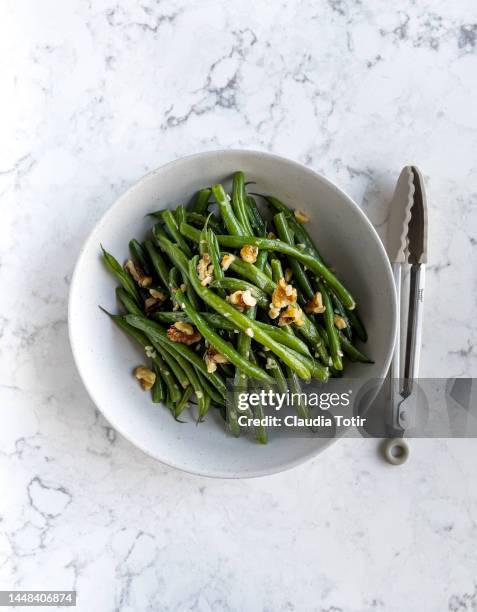 bowl of green beans salad on white, marble background - green bean stockfoto's en -beelden