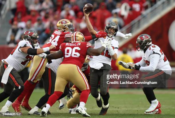 Tom Brady of the Tampa Bay Buccaneers throws the ball while under pressure from Charles Omenihu and T.Y. McGill of the San Francisco 49ers during the...