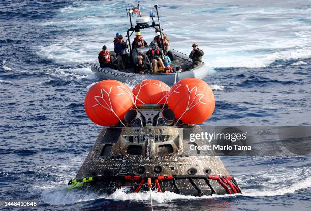 S Orion Capsule is drawn to the well deck of the U.S.S. Portland after it splashed down following a successful uncrewed Artemis I Moon Mission on...