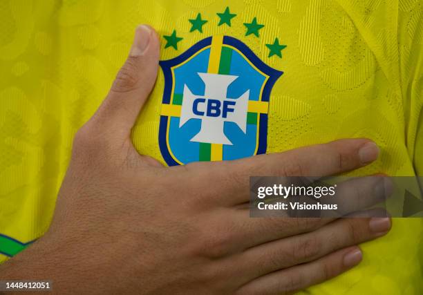 Brazil fan holds the Brazil badge on their shirt during the national anthem ahead of the FIFA World Cup Qatar 2022 quarter final match between...