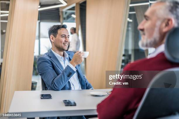 geschäftsmann genießt einen kaffee in einem büro - finanzanalyst stock-fotos und bilder