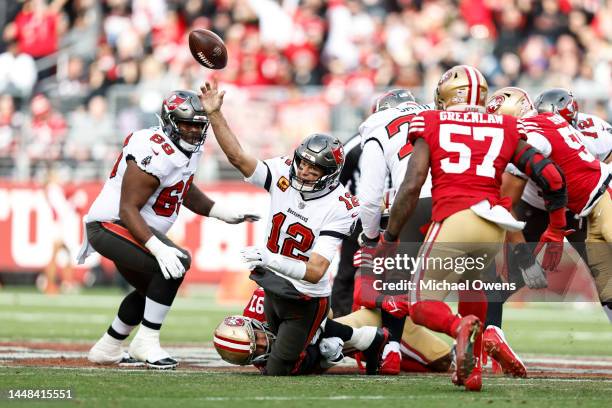 Tom Brady of the Tampa Bay Buccaneers attempts to pass as he is tackles by Nick Bosa of the San Francisco 49ers during an NFL football game between...