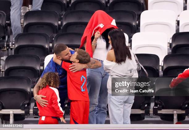 Kyle Walker of England and his wife Annie Kilner - hiding below a sweatshirt - following the FIFA World Cup Qatar 2022 quarter final match between...