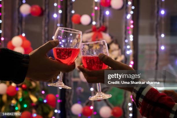 friends holding wine glasses with christmas decorations in background. - adult cocktail party background stock-fotos und bilder