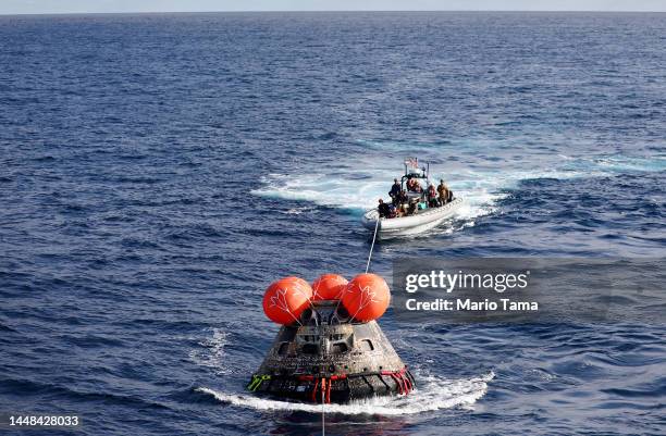 S Orion Capsule is drawn to the well deck of the U.S.S. Portland after it splashed down following a successful uncrewed Artemis I Moon Mission on...