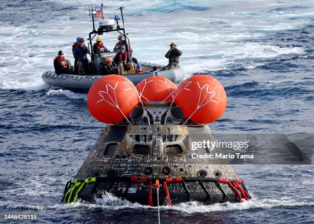 S Orion Capsule is drawn to the well deck of the U.S.S. Portland after it splashed down following a successful uncrewed Artemis I Moon Mission on...