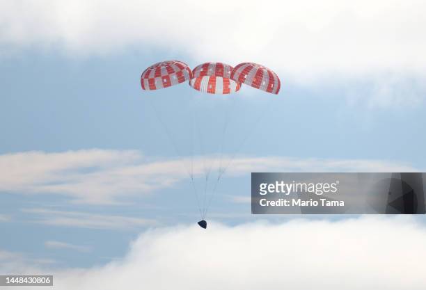 S Orion Capsule descends toward splash down after a successful uncrewed Artemis I Moon Mission on December 11, 2022 seen from aboard the U.S.S....