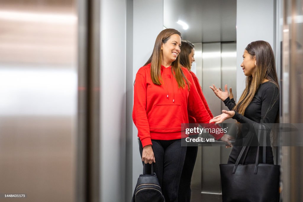 Colleagues talking in an elevator after work