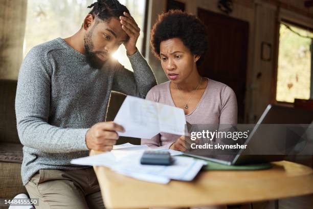 worried black couple having problems with their financial bills at home. - debt free stock pictures, royalty-free photos & images