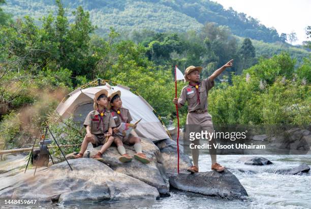 children scouts boys having fun during adventure travel. - asian child with binoculars stockfoto's en -beelden