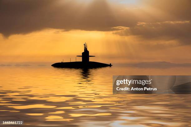 nuclear submarine at sea at sunset. submarine fleet - submarine stock pictures, royalty-free photos & images