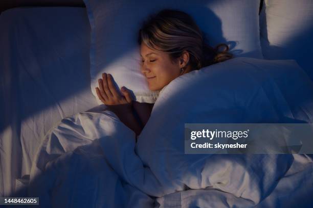 above view of smiling woman sleeping in bed. - positive emotion stock pictures, royalty-free photos & images