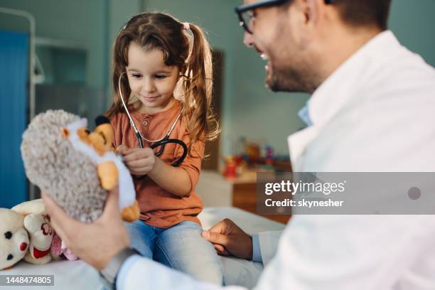 cute girl having a medical exam at her pediatrician. - stuffed toy stock pictures, royalty-free photos & images