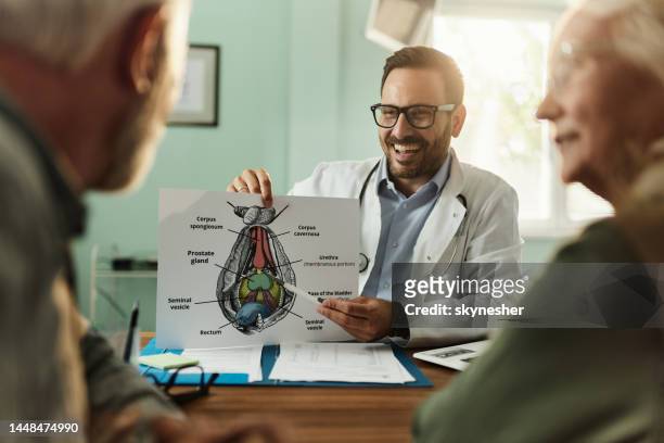 happy male doctor talking to his patients about prostate in the office. - prostate stockfoto's en -beelden
