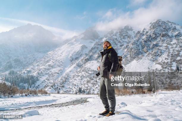 man planning his path, looking up at snowy mountain canyon peak - kyrgyzstan people stock pictures, royalty-free photos & images