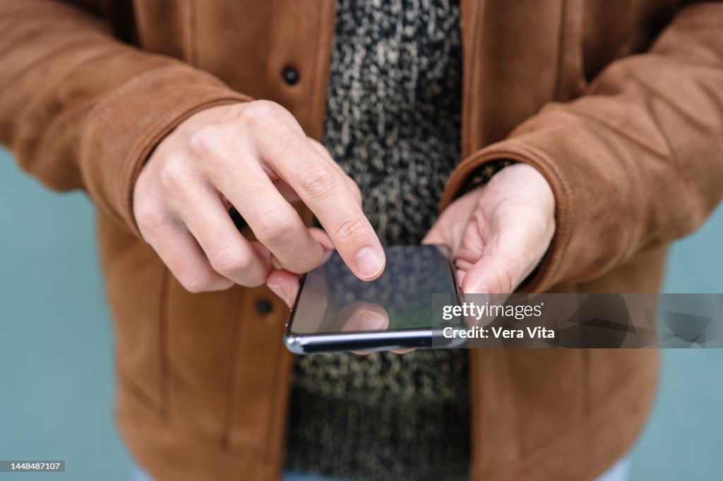 Close up of caucasian man hands pointing with finger on smartphone