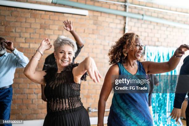 porträt einer älteren frau, die mit ihren freunden in einem tanzsaal tanzt - elderly dancing stock-fotos und bilder