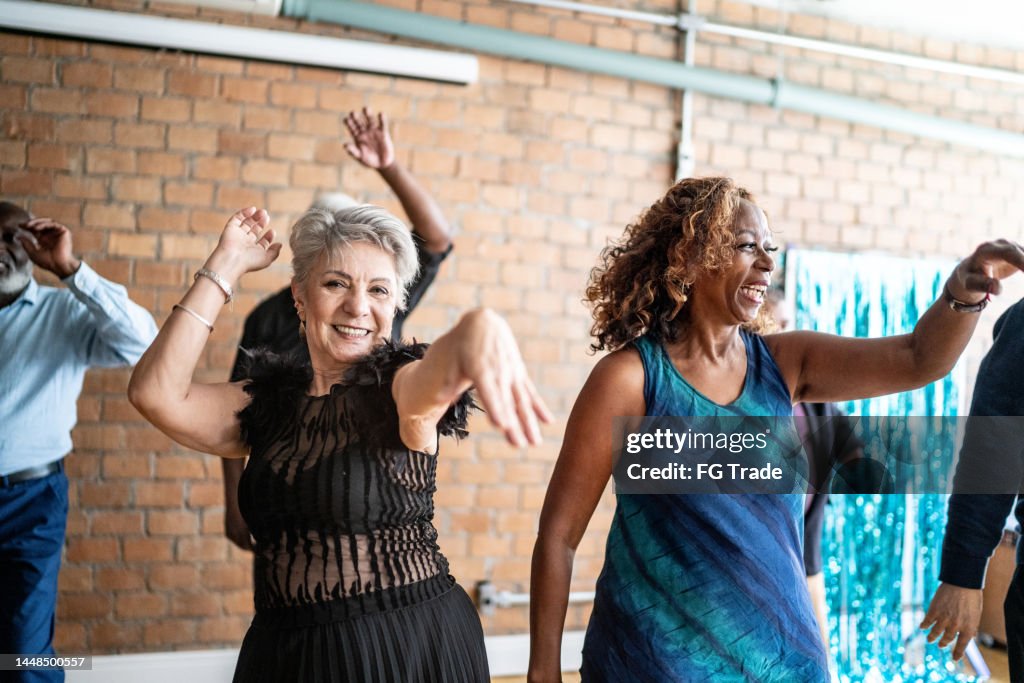Portrait of a senior woman dancing with her friends on a dance hall