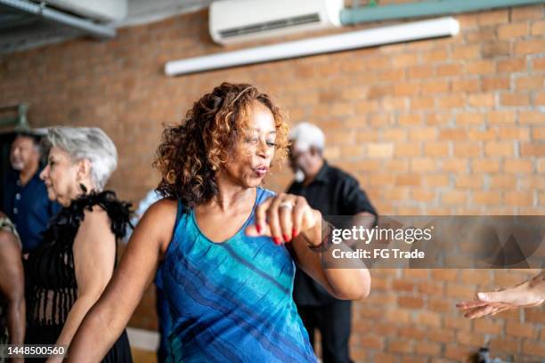 mujer mayor bailando con sus amigos en un salón de baile - dance studio fotografías e imágenes de stock