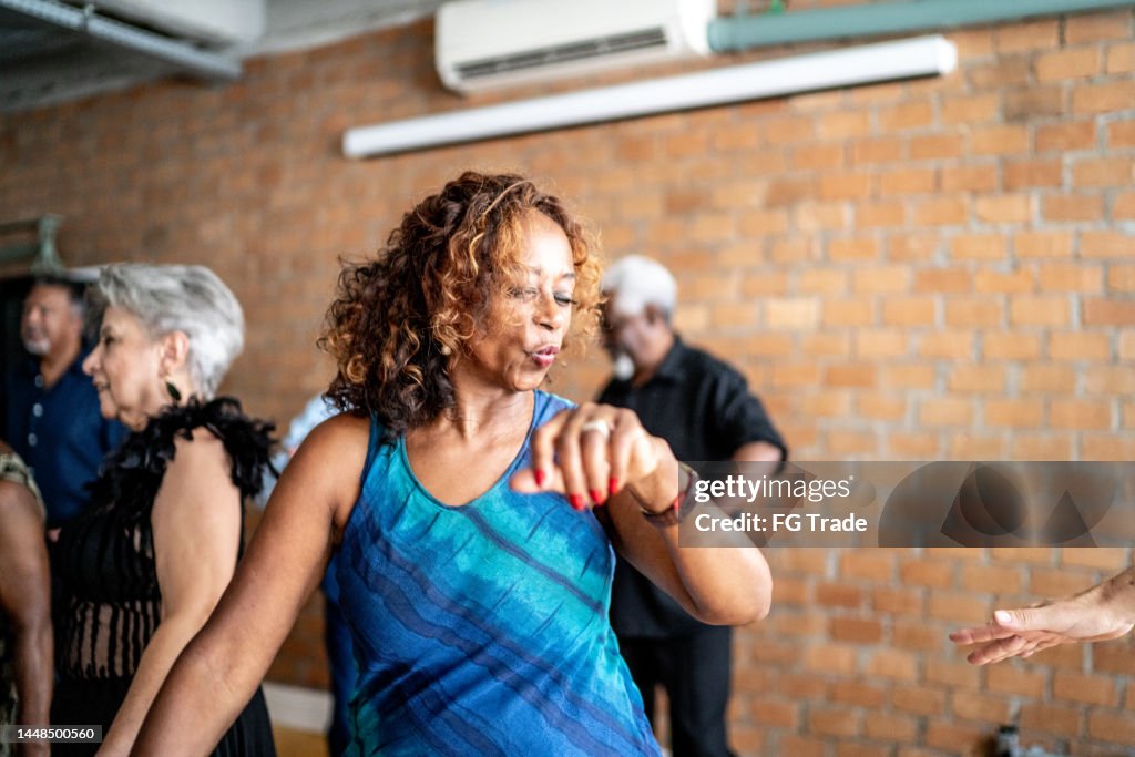 Senior woman dancing with her friends on a dance hall