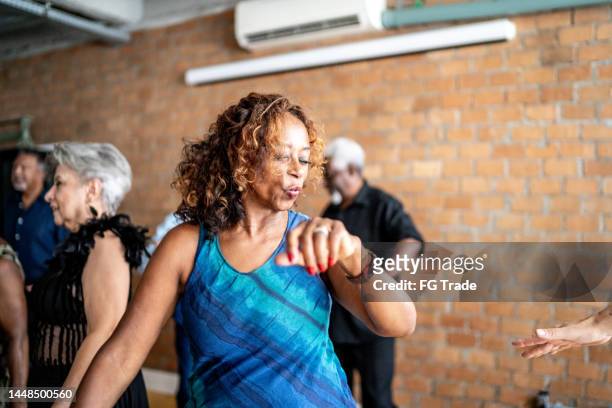 senior woman dancing with her friends on a dance hall - body issue celebration party stock pictures, royalty-free photos & images