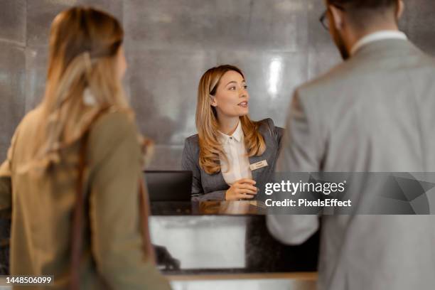 recepcionista na recepção conversando com o hóspede no hotel - balcão de check in do aeroporto - fotografias e filmes do acervo