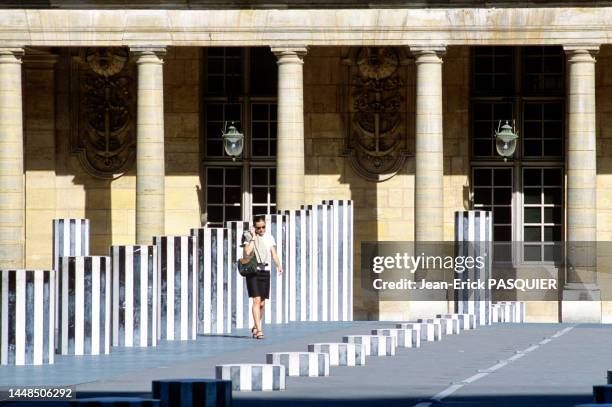 Jeune femme avec un téléphone portable entre les colonnes de Buren dans les jardins du Palais Royal en 1996 à Paris.
