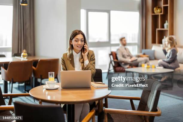 business woman talking on phone - business class lounge stock pictures, royalty-free photos & images