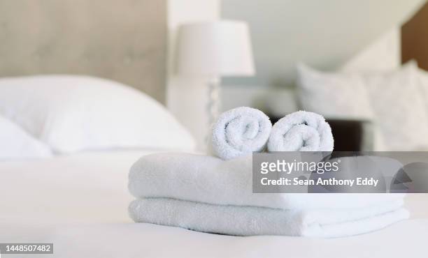 leeres zimmer, gastfreundschaft und saubere handtücher auf einem bett in einer wohnung, einem resort oder einem motel. hotel, liebe zum detail und vorbereitung für kunden in einem spa mit luxuriösen weichen stoffen, leinen und baumwolltuch. - airbnb stock-fotos und bilder