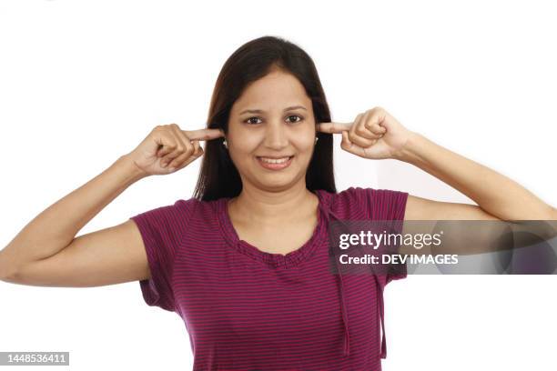 young woman  covering ears with fingers - noise and stress concept - woman fingers in ears fotografías e imágenes de stock