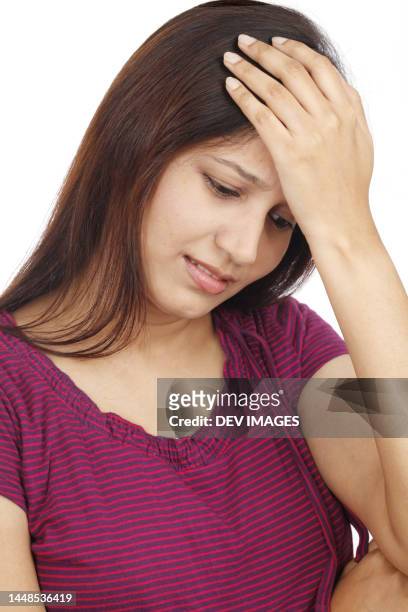 young woman with a headache on white background - woman head in hands sad stock pictures, royalty-free photos & images