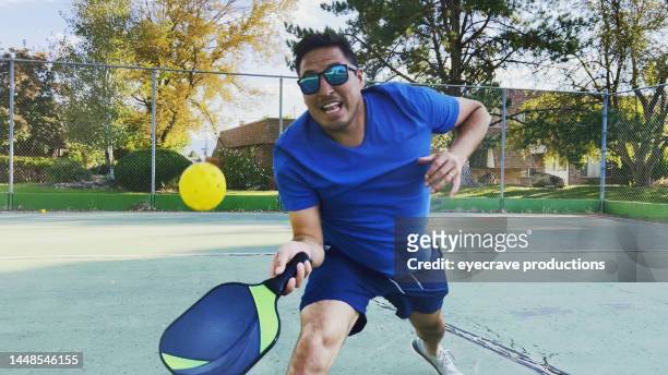 colombian american hispanic couple playing pickle-ball on sunny autumn day photo series - doubles sports stock pictures, royalty-free photos & images