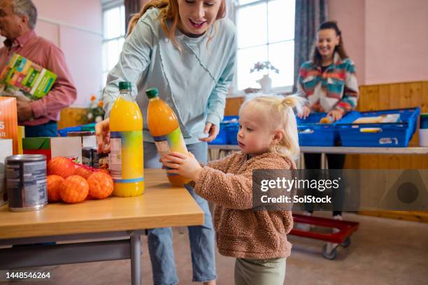 single mother at a food bank - food pantry stock pictures, royalty-free photos & images