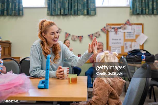 single mother using a warm hub - kids at community center stock pictures, royalty-free photos & images