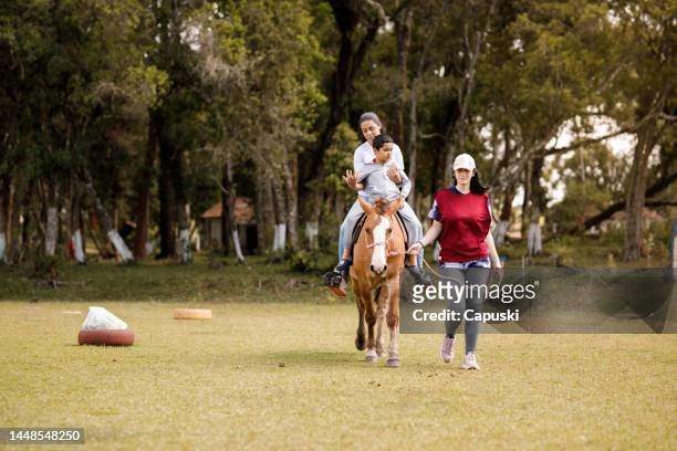 frauen nehmen einen kleinen jungen mit auf einen ausritt in der natur - horse and male and riding stock-fotos und bilder