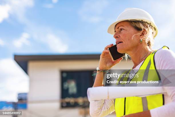wohnhausentwicklung weibliche bauunternehmerin mit blaupausen auf der baustelle fotoserie - schrumpfen stock-fotos und bilder