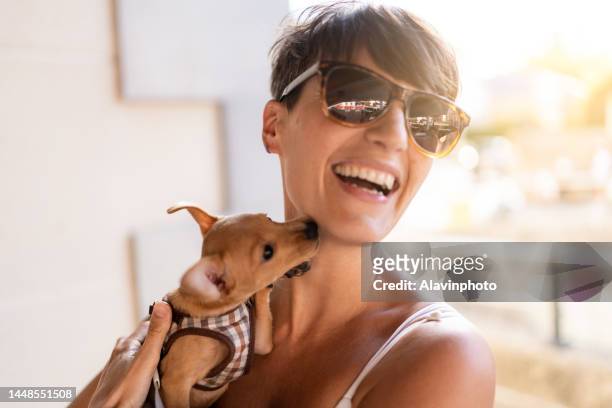 young woman in the street with her puppy dog - little dog owner stock pictures, royalty-free photos & images