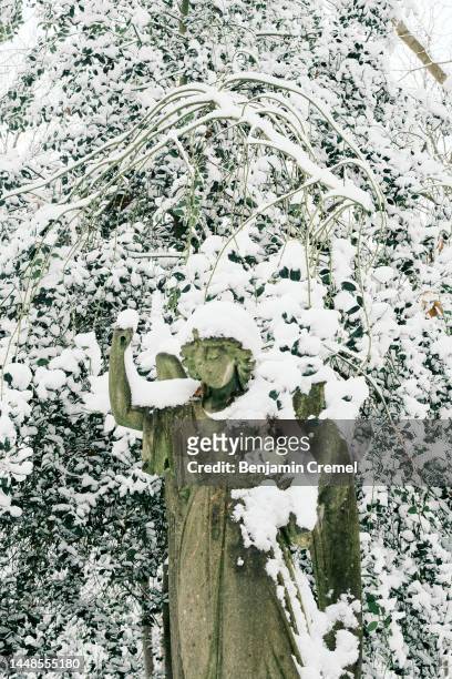 Gravestone is covered in snow at Highgate Cemetery on December 12, 2022 in London, England. Snow and ice disrupted rail travel and closed schools in...