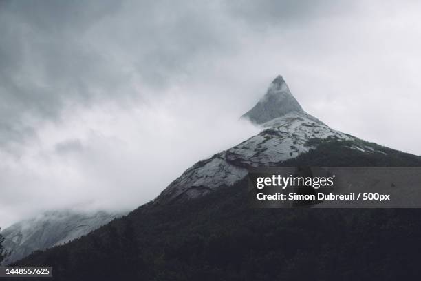 low angle view of snowcapped mountain against sky,stetind,narvik municipality,norway - stetind stock pictures, royalty-free photos & images