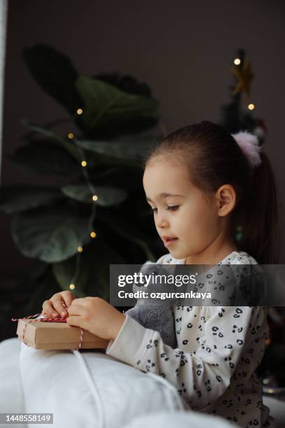 クリスマスツリーで朝に贈り物を持つ幸せな子供の女の子 - koala ストックフォトと画像