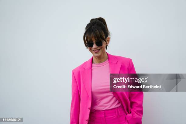 Sophie Marceau wears earrings, sunglasses, a pastel pink t-shirt, a neon pink oversize blazer jacket, outside the "Le Raphia" Jacquemus show on...