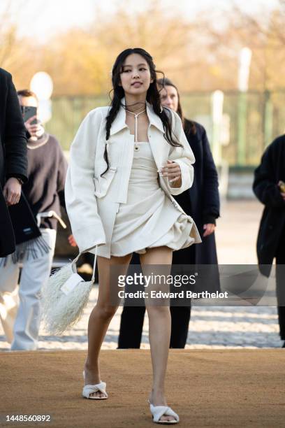 Jennie Kim from Blackpink wears a white oversize jacket, a necklace, a white ruffled and gathered mini dress, a white fluffy bag from Jacquemus,...